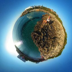 Man in sea against clear blue sky