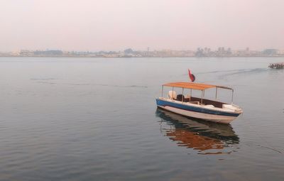 Boat in sea against sky during sunset