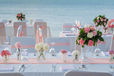 Flowers on table by sea