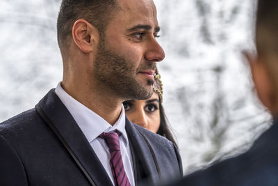 Close-up of bridegroom with bride during wedding ceremony