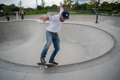 Full length of man skateboarding on skateboard in city