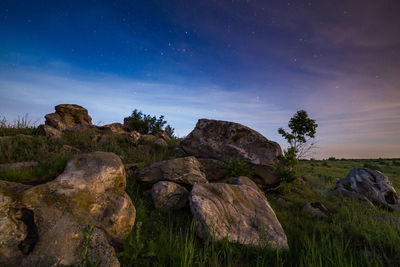Night landscape with rocks on summer field