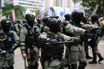 Police force standing on street in city