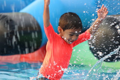 Close-up of boy splashing water at swimming pool