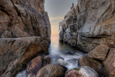 Panoramic shot of rock formation in sea against sky