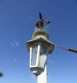 Low angle view of lighting equipment against clear blue sky