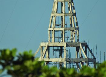 Low angle view of electricity pylon against clear blue sky