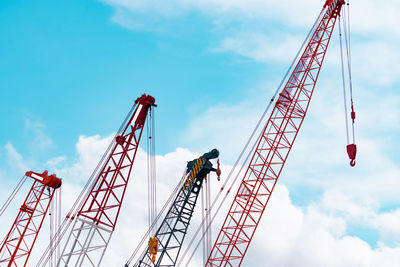 Crawler crane against blue sky and white clouds. real estate industry. red crawler crane.