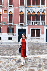 Young tourist in dress and coat on the streets of venice