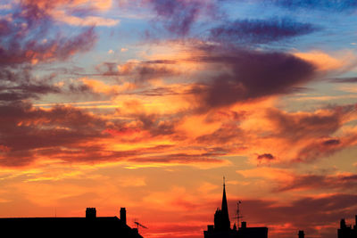 High section of silhouette built structures against scenic sky