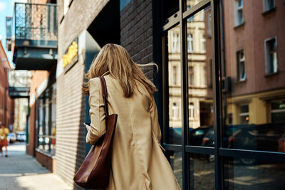 Woman in coat walks at city stret