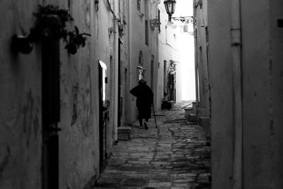 Rear view of man walking in alley