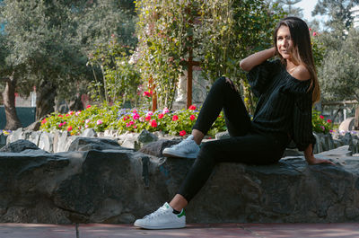 Full length of woman sitting at park