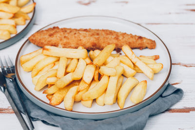 High angle view of meat and fries in plate on table