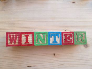 High angle view of winter text carved on wooden toy blocks