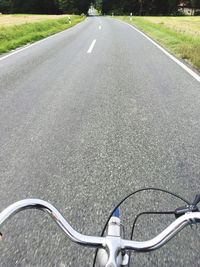 Cropped image of man riding bicycle on road