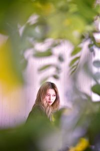 Woman looking away against wall