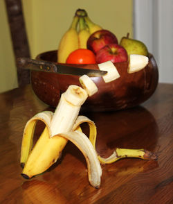 Knife cutting banana mid-air on table