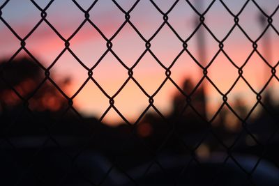 Close-up of chainlink fence during sunset