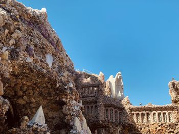 Low angle view of old ruin building against blue sky