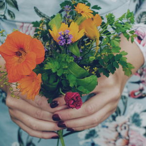 Midsection of woman holding flowers bouquet