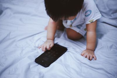 High angle view of child lying on bed