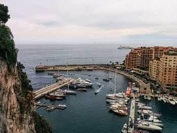 Yachts and boats are parked in monaco. mediterranean coast. mountains and tall buildings in the city