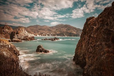 Scenic view of sea and mountains against sky