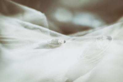 High angle view of wedding rings on bed