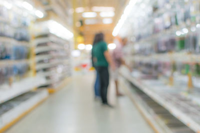 Blurred motion of woman walking in illuminated store