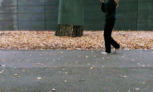 Low section of woman standing on road