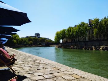View of swimming pool by river against sky