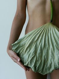 Midsection of woman standing against white background