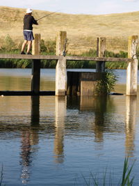 Rear view of man standing by lake