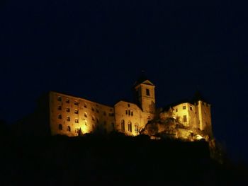 Low angle view of illuminated buildings against sky at night