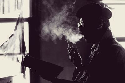 Young man smoking cigarette at home