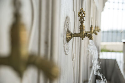 Flowing water from golden faucet at mosque