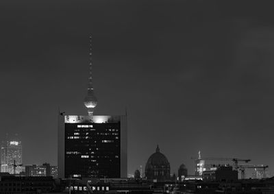 Communications tower in city at night