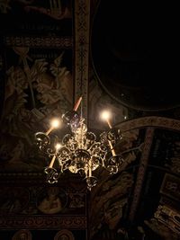 Low angle view of illuminated chandelier hanging in building