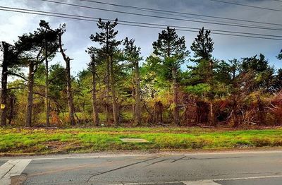 Power line on road against sky