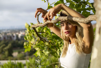 Portrait of young woman with arms raised