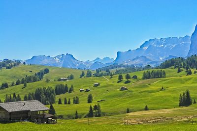 Scenic view of landscape and mountains against clear blue sky