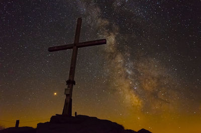 Low angle view of cross against sky at night