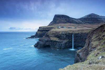 Scenic view of sea and mountains against blue sky