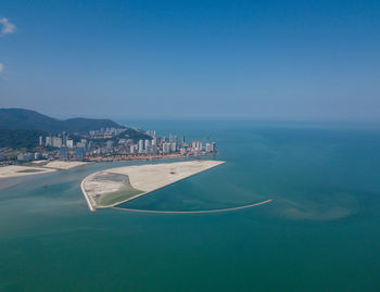 Aerial view of bay against clear blue sky