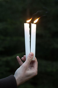 Close-up of hand holding candles