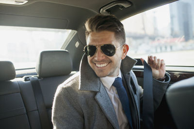 Young businessman in car service limousine