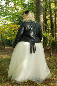 Rear view of woman standing against trees