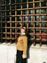 Portrait of woman standing against wall