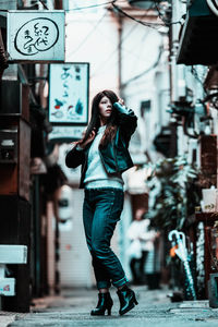 Full length portrait of young woman in city